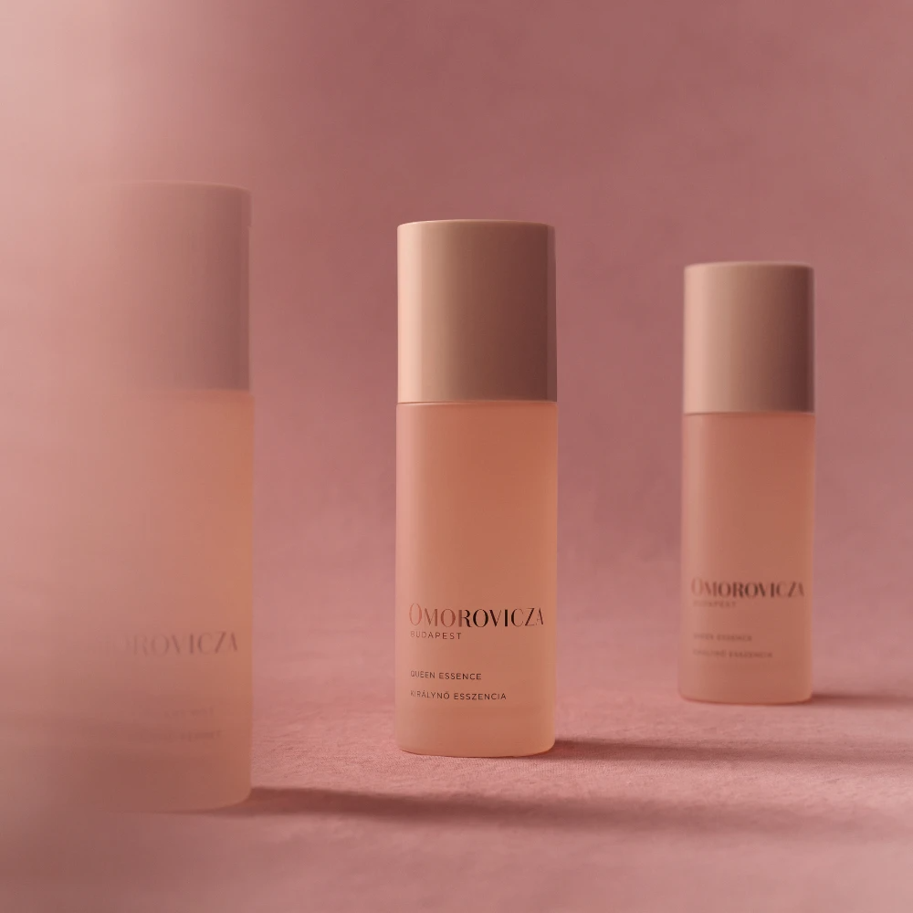 Hedvábná hydratační esence Omorovicza (Queen Essence) v růžové produktové kompozici